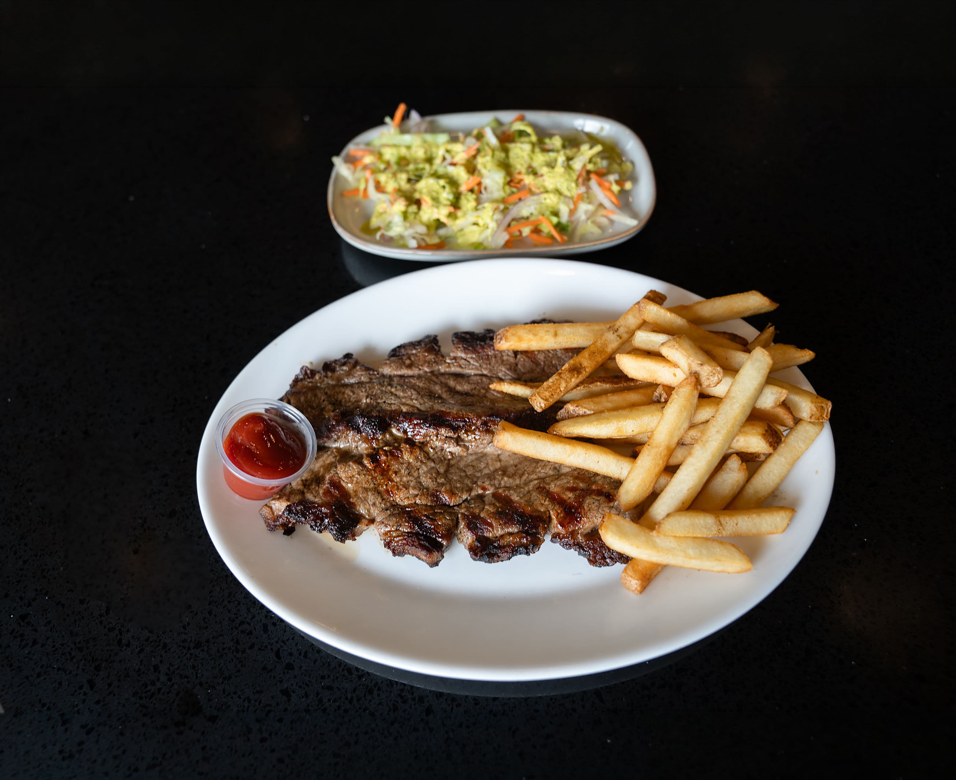 Grilled Argentinian-style steak served with fries and salad.